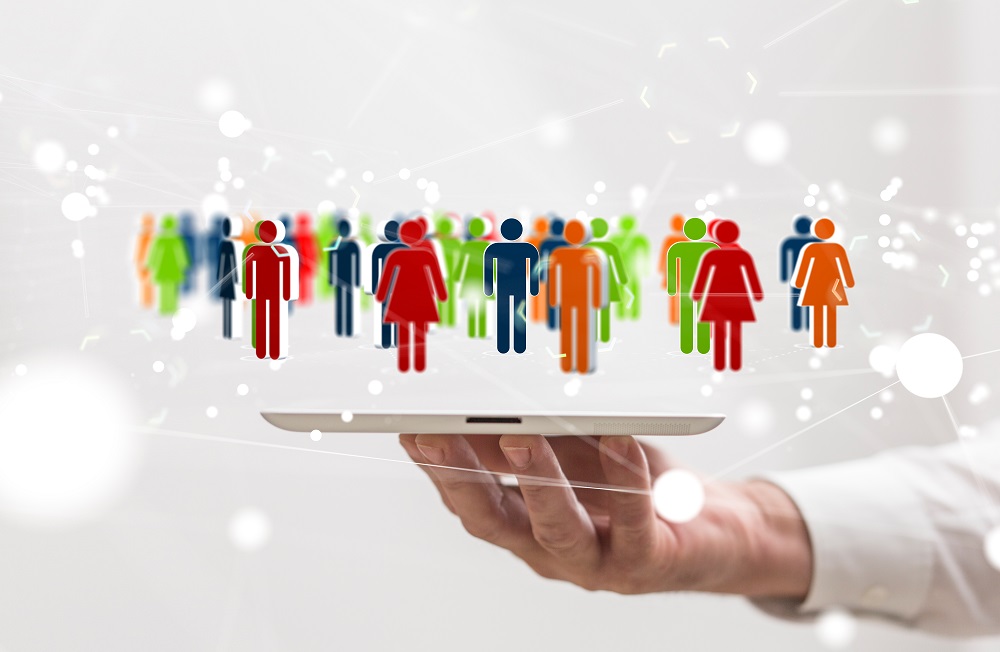 Hand hält Tablet mit farbigen Figuren darauf