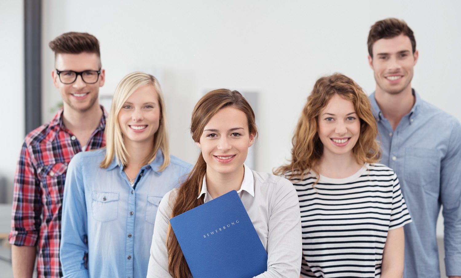 Junges Team, im Vordergrund 3 junge Frauen, außen stehend 2 junge Männer