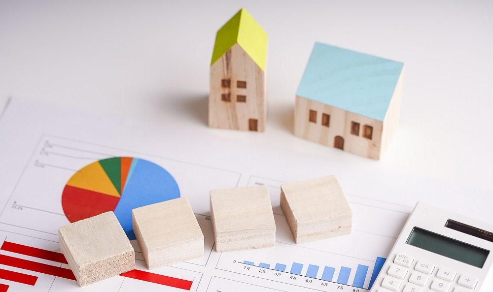 Holzhäuschen, Klötzchen und Taschenrechner auf Statistikplan